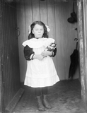 Young girl in porch door, holding a doll