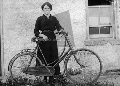 Unknown woman standing leaning against a bike