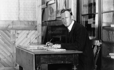 John H Smith sitting writing at his desk