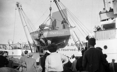 Yacht being hoisted up by ST NINIAN II's crane